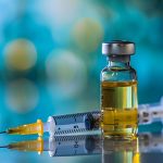 Vorbereitung einer Impfspritze mit Nadel und Durchstechflasche mit gelber Injektionslösung